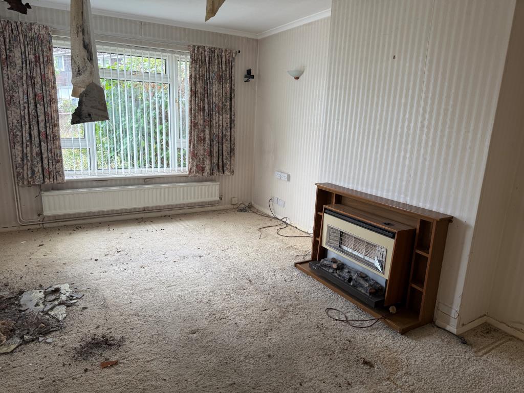 Lot: 159 - BUNGALOW WITH GARAGE AND GARDENS IN NEED OF MODERNISATION - Living room with gas fire and window to front